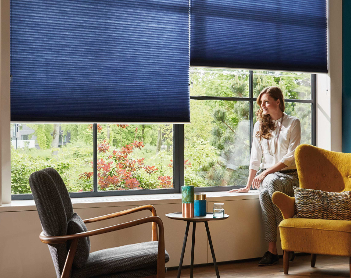 woman looking out of blue blinds